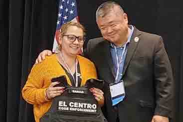 Tim Sun (right) presents a protective vest to Anna Garcia